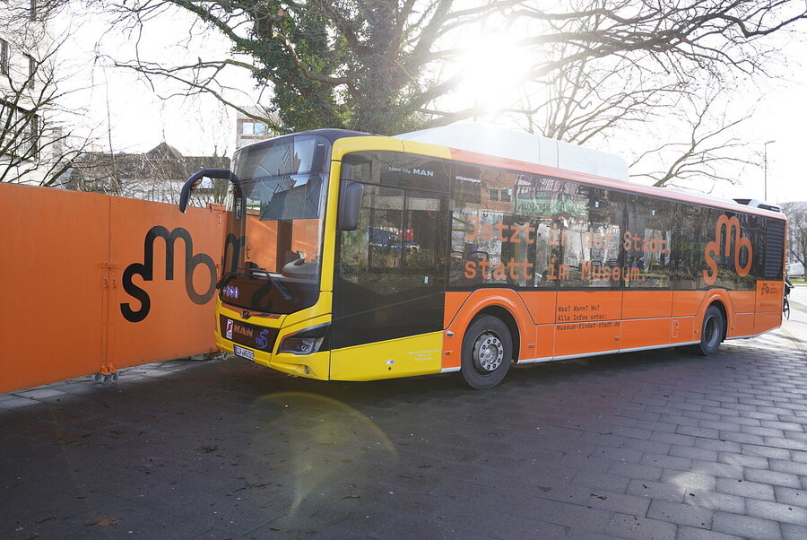 SMO-Bus vor dem Bauzaun des Stadtmuseums