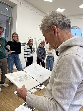 Künstler Jens Thiele bespricht mit den Schülerinnen und Schülern ihre Skizzen zum „Feuervogel“ in der Artothek. Foto: Artothek Oldenburg